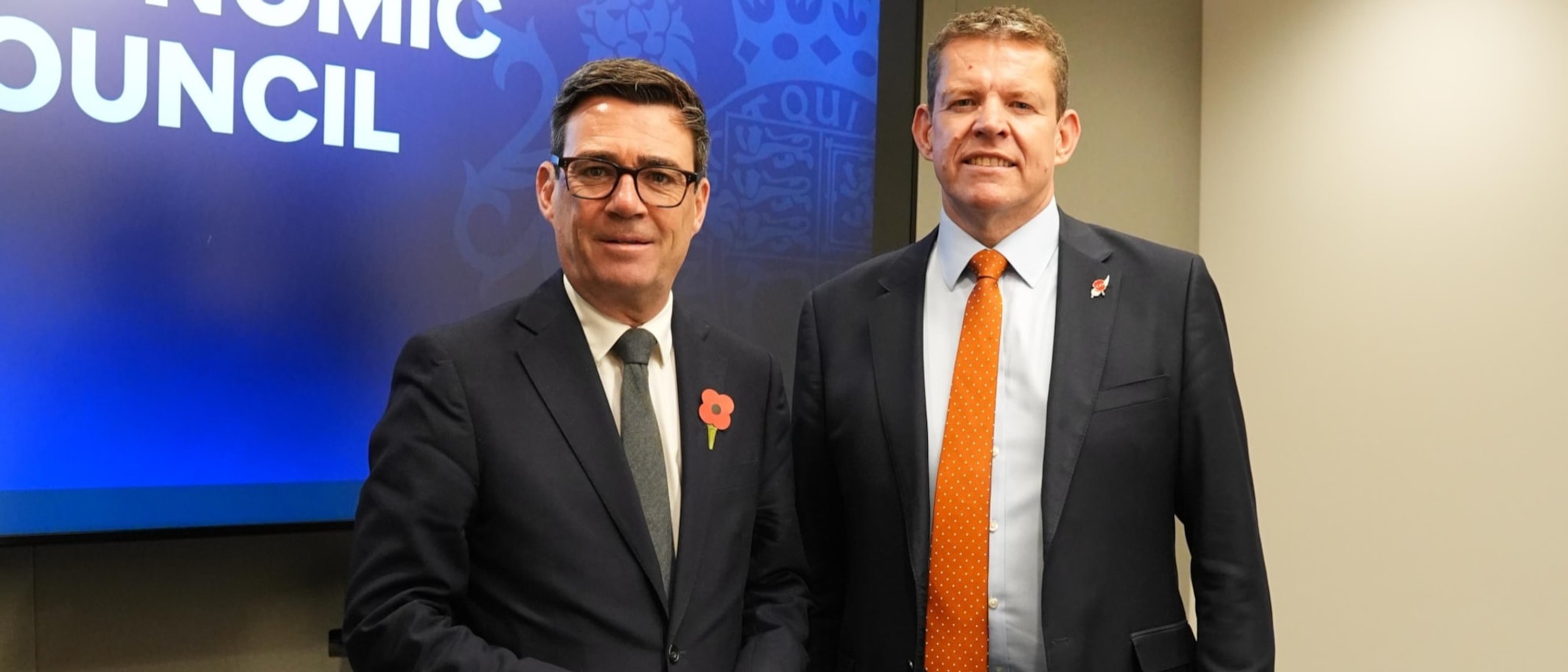 Prime Minister Andy Burnham and First Minister Rhun ap Iorwerth stand side by side in front of a National Economic Council screen