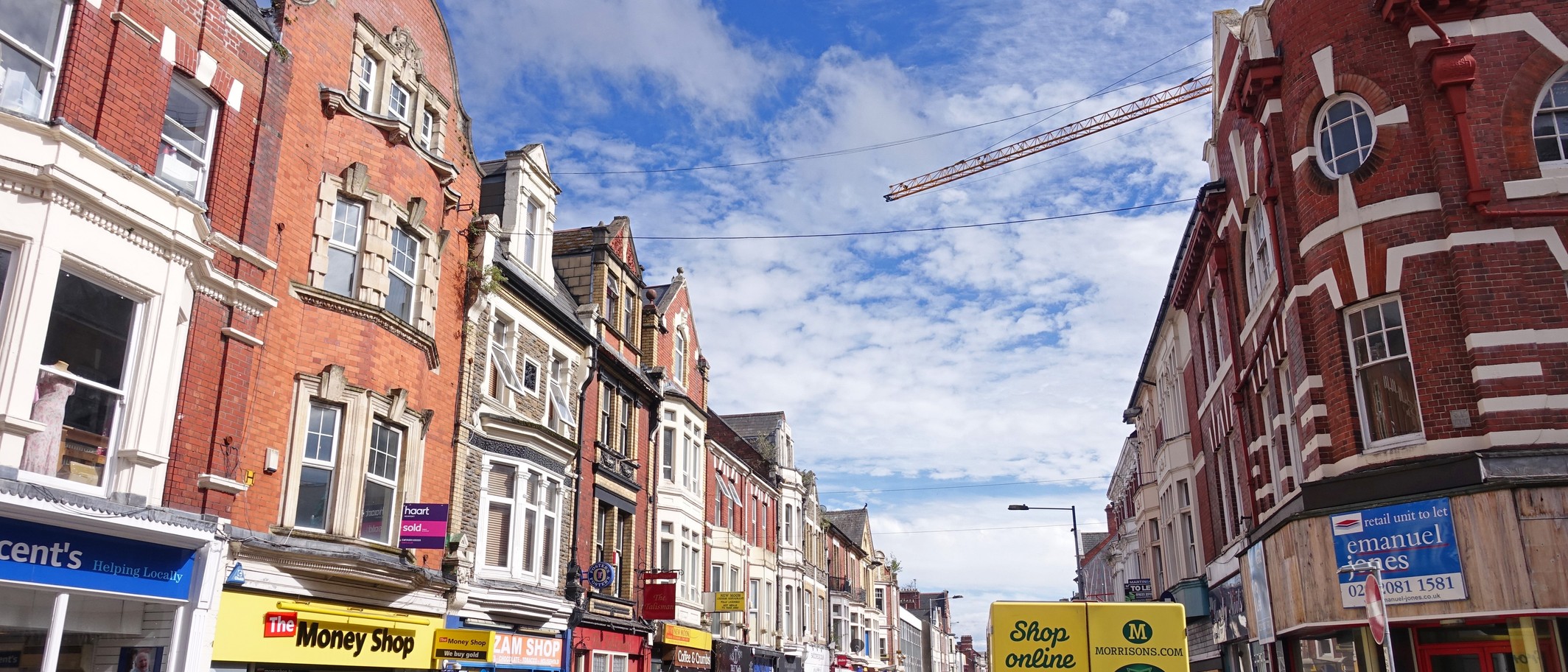 Commercial Street in Newport city centre, shops beneath Victorian shopfronts and a construction crane over the rooftops. Photo: Tiia Monto, CC BY-SA 3.0, via Wikimedia Commons (commons.wikimedia.org/wiki/File:Newport_-_Commercial_Street.jpg)