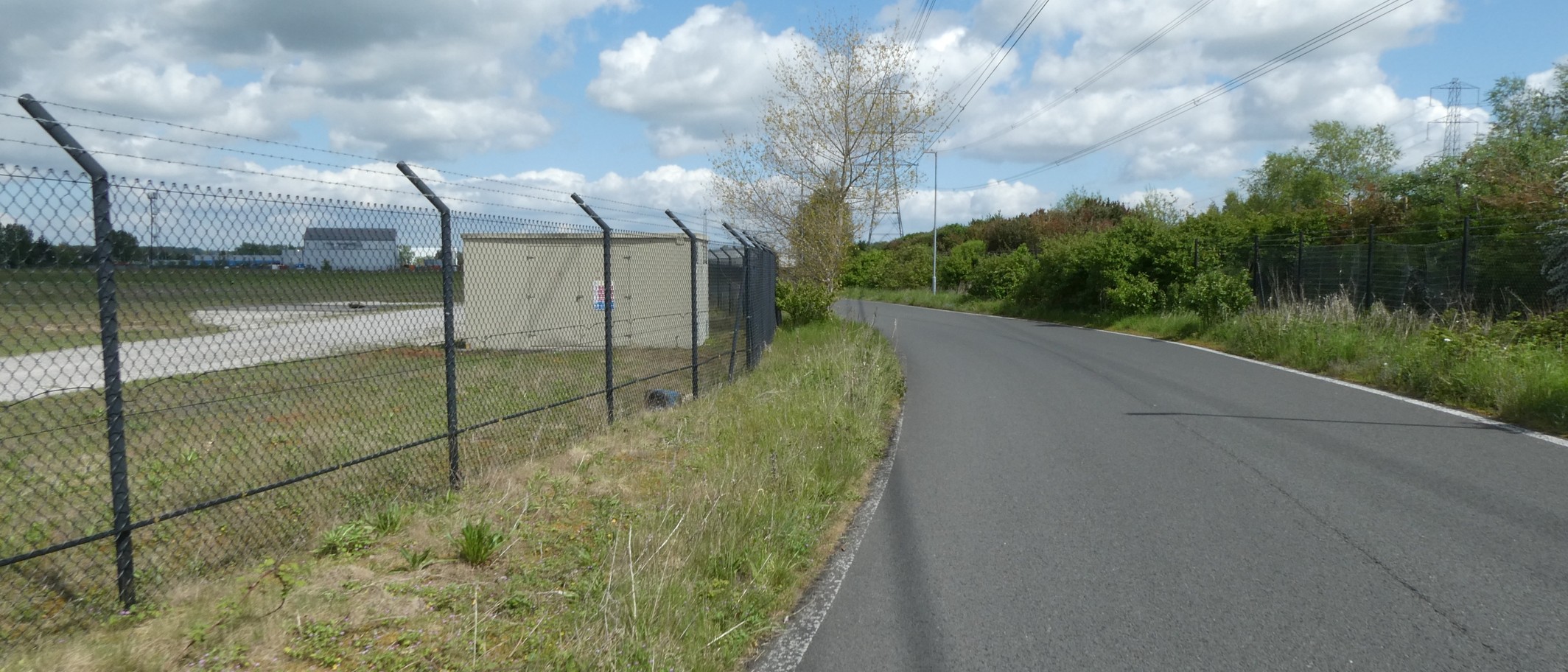 Road beside Deeside Industrial Estate, 7 May 2023. Archive geographic context, not Polytag’s premises, a detection unit or a recycling line. David Smith / Geograph and Wikimedia Commons, CC BY-SA 2.0; cropped.