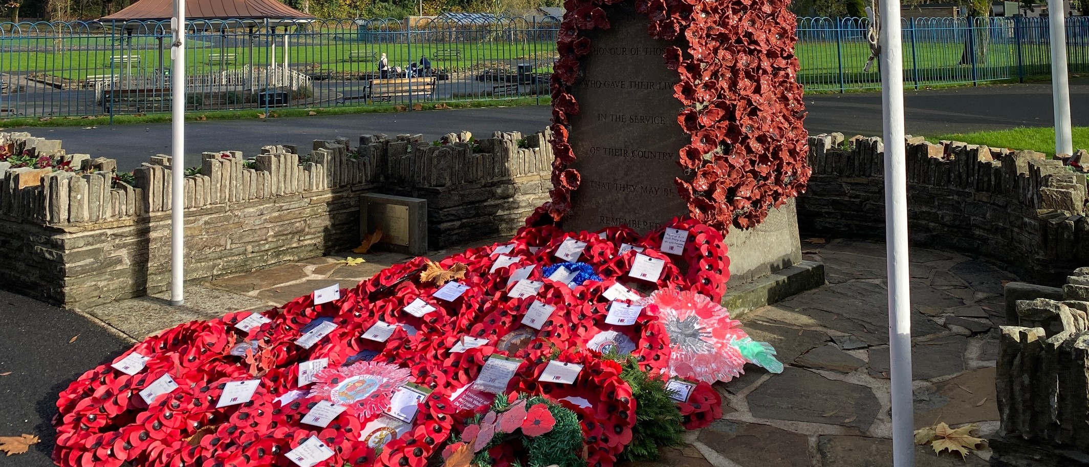 Poppy wreaths at the war memorial in Ynysangharad Park, Pontypridd, on 13 November 2025. Archive photograph, not the forthcoming 2026 parade. Alan Hughes / Geograph and Wikimedia Commons, CC BY-SA 2.0; cropped.