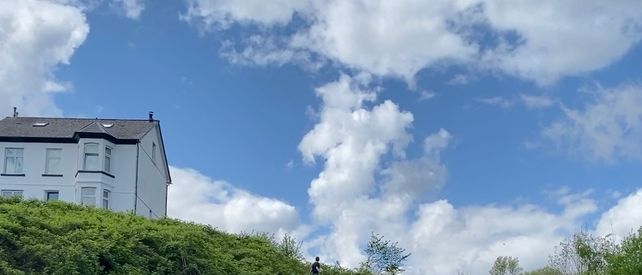 A person walking a small dog on a path in Ynyshir, photographed by Alan Hughes.
