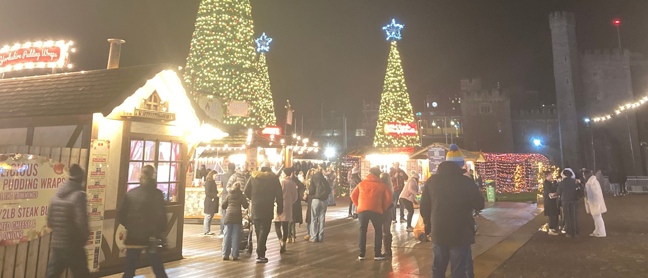 Christmas trees and market chalets at Cardiff's Winter Wonderland by Cardiff Castle, December 2024. Archive photo. Seth Whales / Wikimedia Commons, CC BY-SA 4.0; cropped.