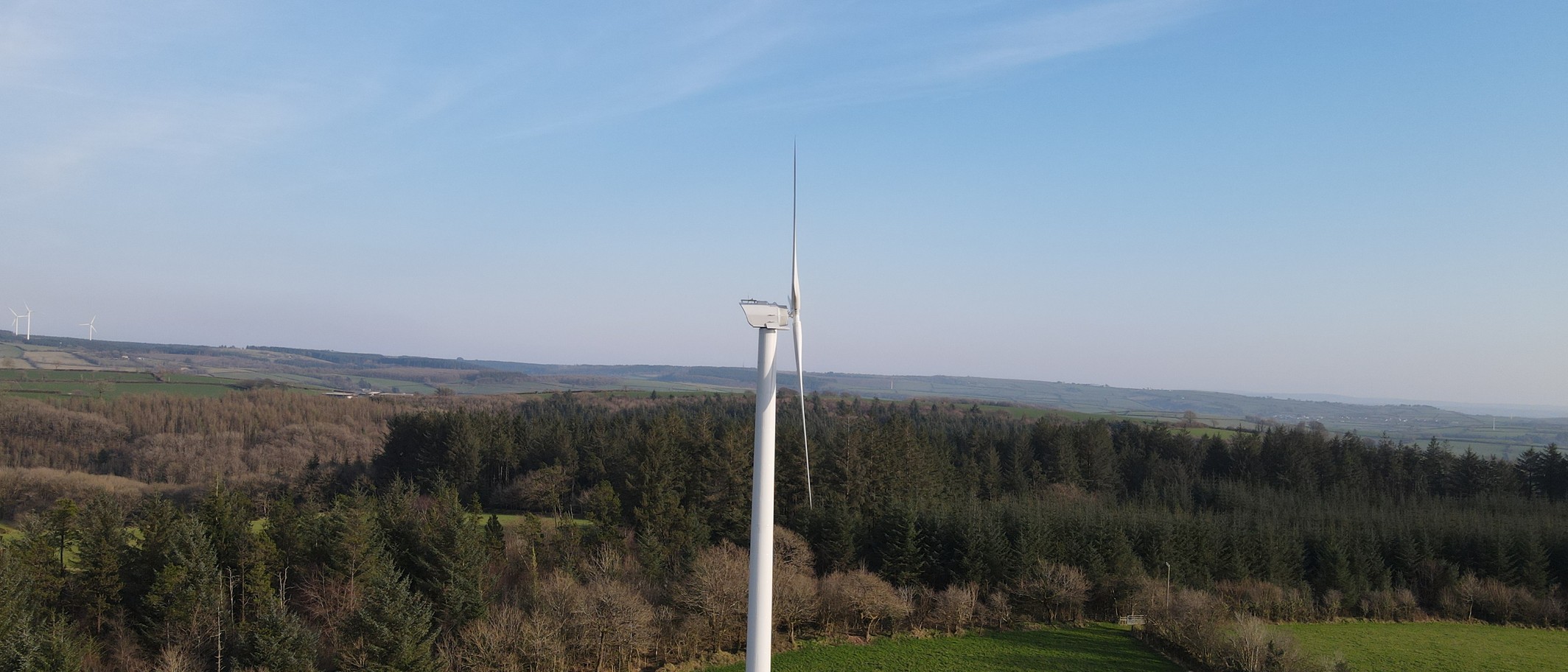 Skanda Vale’s wind turbine, funded through an earlier Ynni Cymru round. Archive photograph supplied by Welsh Government, Open Government Licence v3.0; cropped.