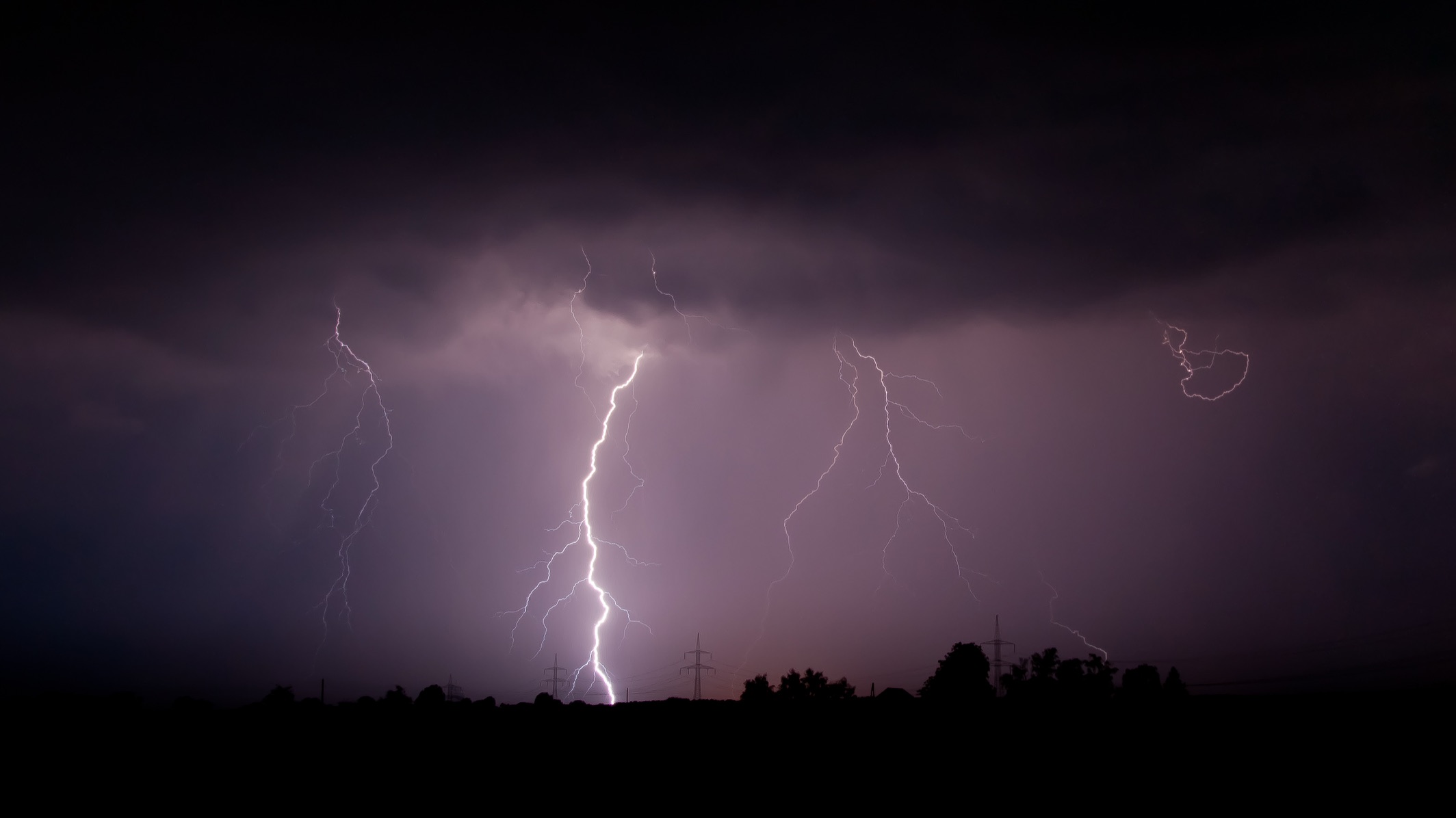 Forked lightning striking from a dark storm cloud over open country at night (library photograph, Mathias Krumbholz, CC BY-SA 3.0)